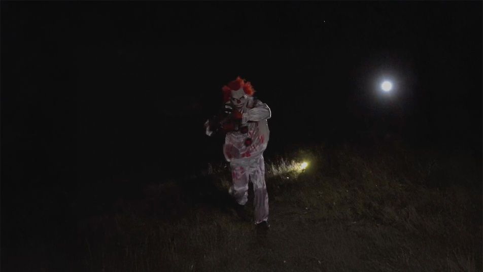 Clown som närmar sig i mörkret under Halloween Clown Walk